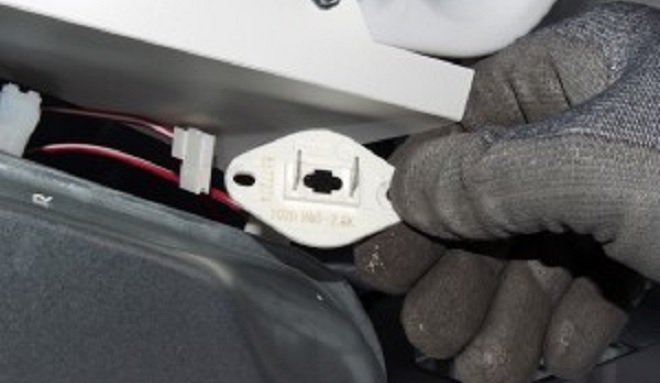 Image of an Sears Home Services Technician removing a dryer thermistor