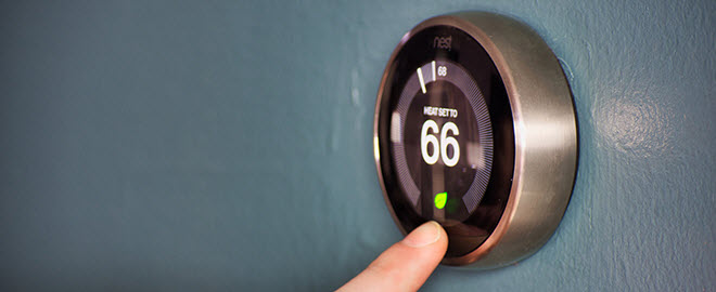 Image of homeowner setting Nest thermostat