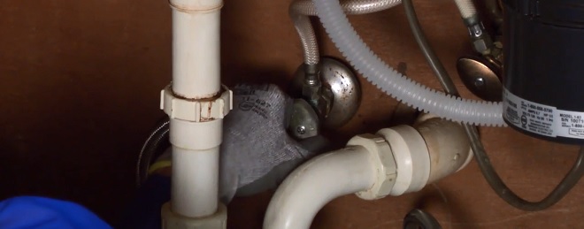 Image of installer opening the dishwasher water supply valve