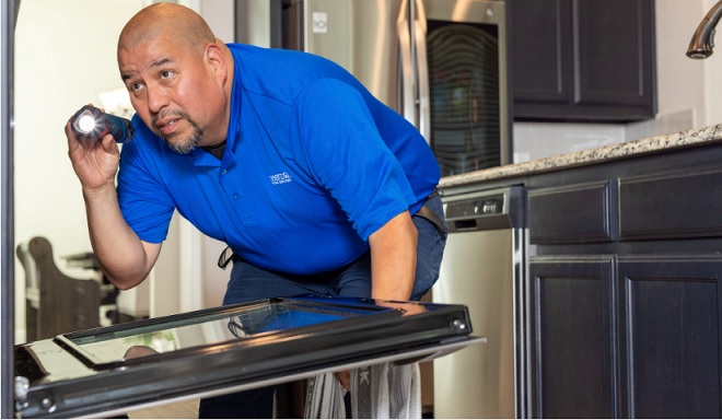 Image of Sears Home Services Technician maintaining the oven