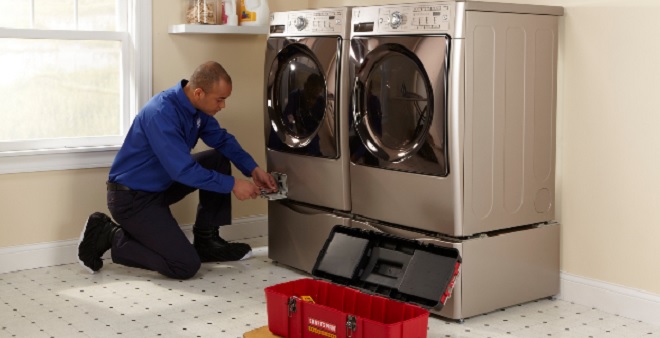 Image of Sears Tech maintaining laundry appliances