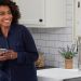Woman on phone smiling in laundry room