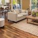 Spacious tan living room with brown faux-bois flooring